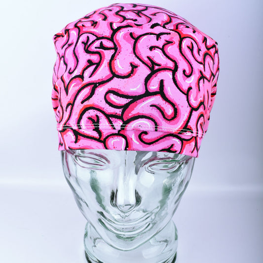 Pink brain-patterned scrub hat on a mannequin head against a white background