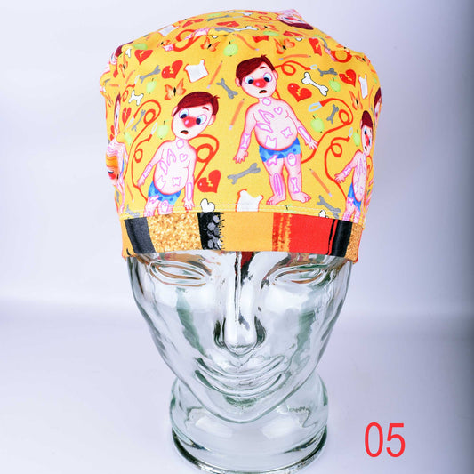 Colorful yellow scrub cap featuring cartoon medical patients and anatomical symbols on a glass mannequin head.