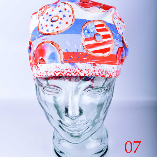 Front view of a patriotic themed medical scrub hat for nurses and doctors with a festive red and blue donut pattern.