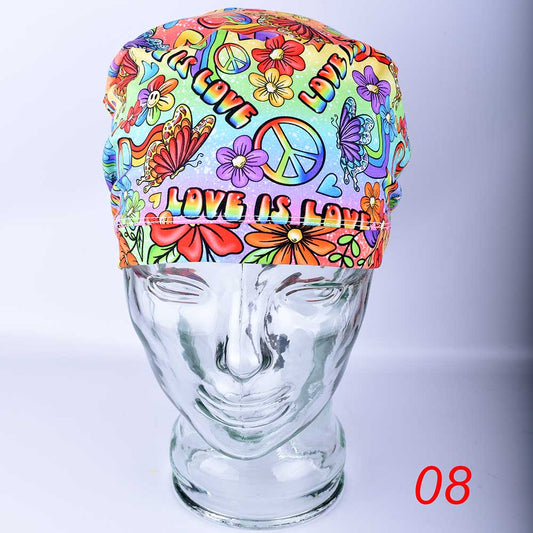 Close-up of Love is Love scrub cap Design 08 featuring vibrant rainbow heart and text pattern on white stretchy cotton fabric.