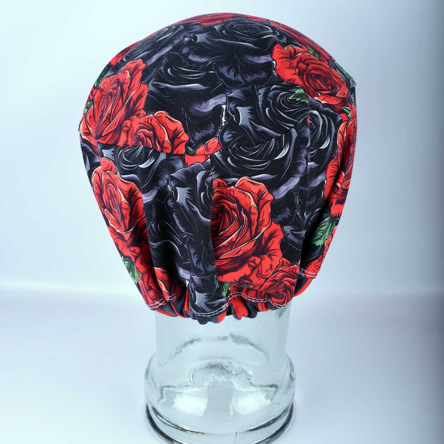 Close-up of the back of a floral scrub hat showing the adjustable cord lock toggle and elastic casing for a secure, custom fit.