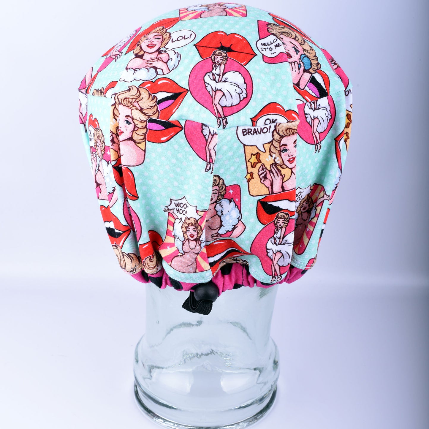 Back of a women's scrub cap showing the adjustable elastic drawstring and white cord lock toggle for a secure, custom fit.