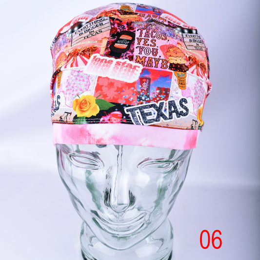 A multicolor collage-patterned surgical cap displayed on a clear glass mannequin head. The pattern features various Texas-themed elements, including the word 'TEXAS', a yellow rose, and a pink band at the bottom.