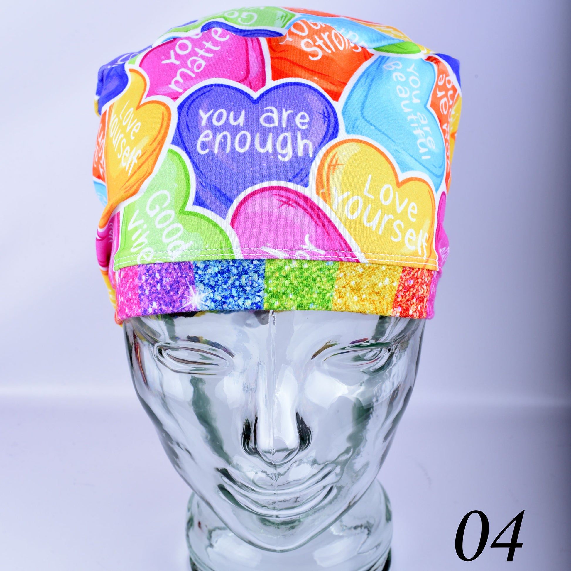 Front close-up view of an adjustable affirmation hearts scrub cap made from premium, stretchy cotton fabric on a mannequin head.