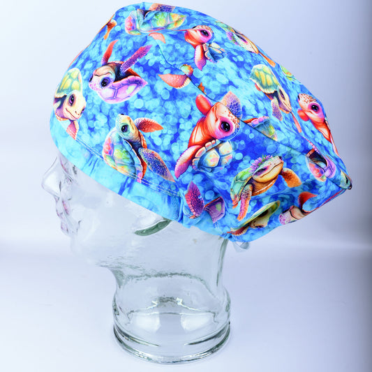 Side view of a fabric scrub cap featuring a vibrant baby sea turtle pattern on a mannequin head, showcasing the secure full coverage fit.