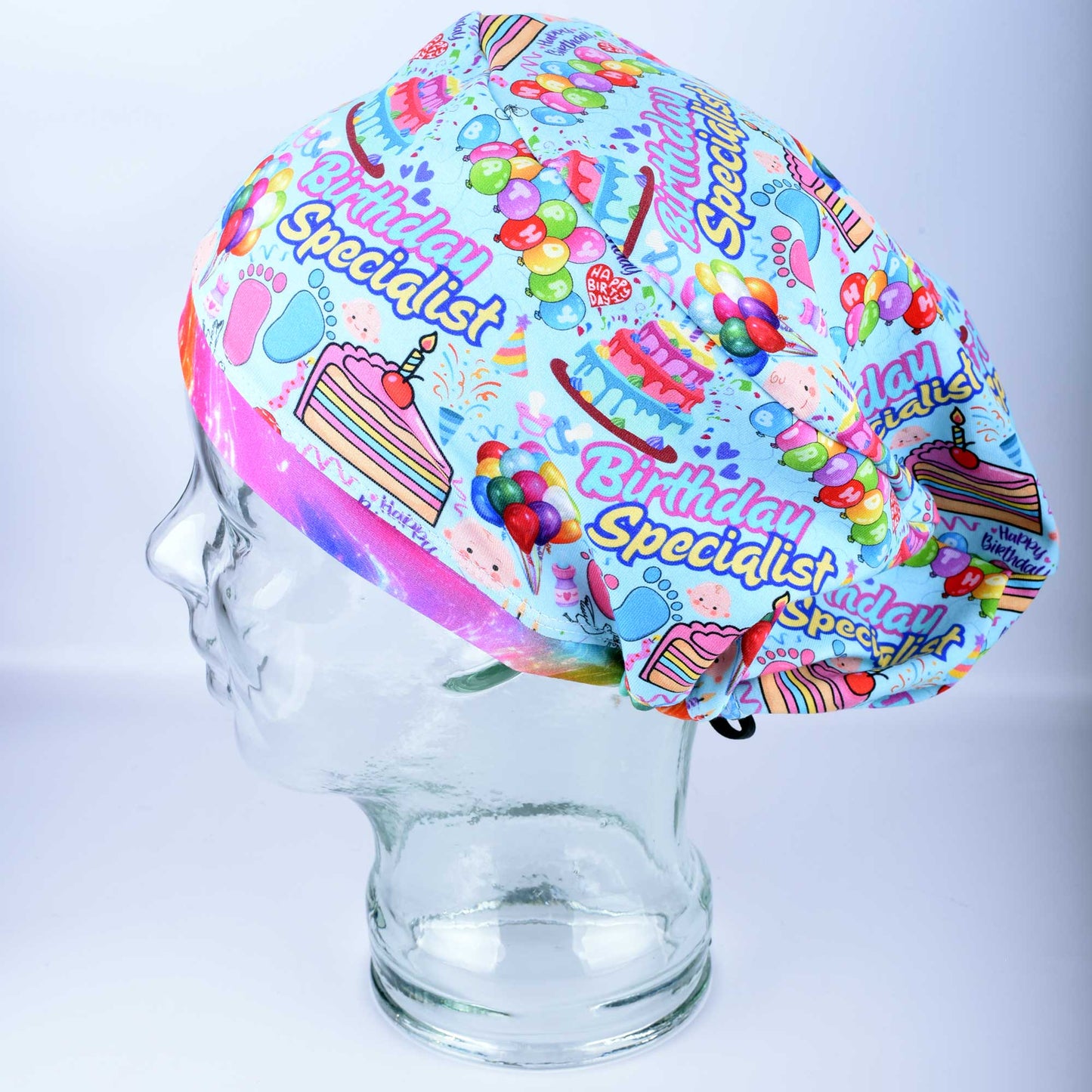 Side profile of a colorful Labor and Delivery scrub cap showing the full-coverage Euro-style design and vibrant celebratory pattern.