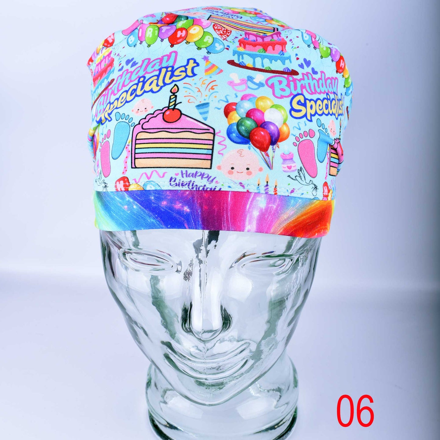 Euro-style scrub cap featuring a colorful "Birthday Specialist" cake and balloon print on a white background, shown on a mannequin head.