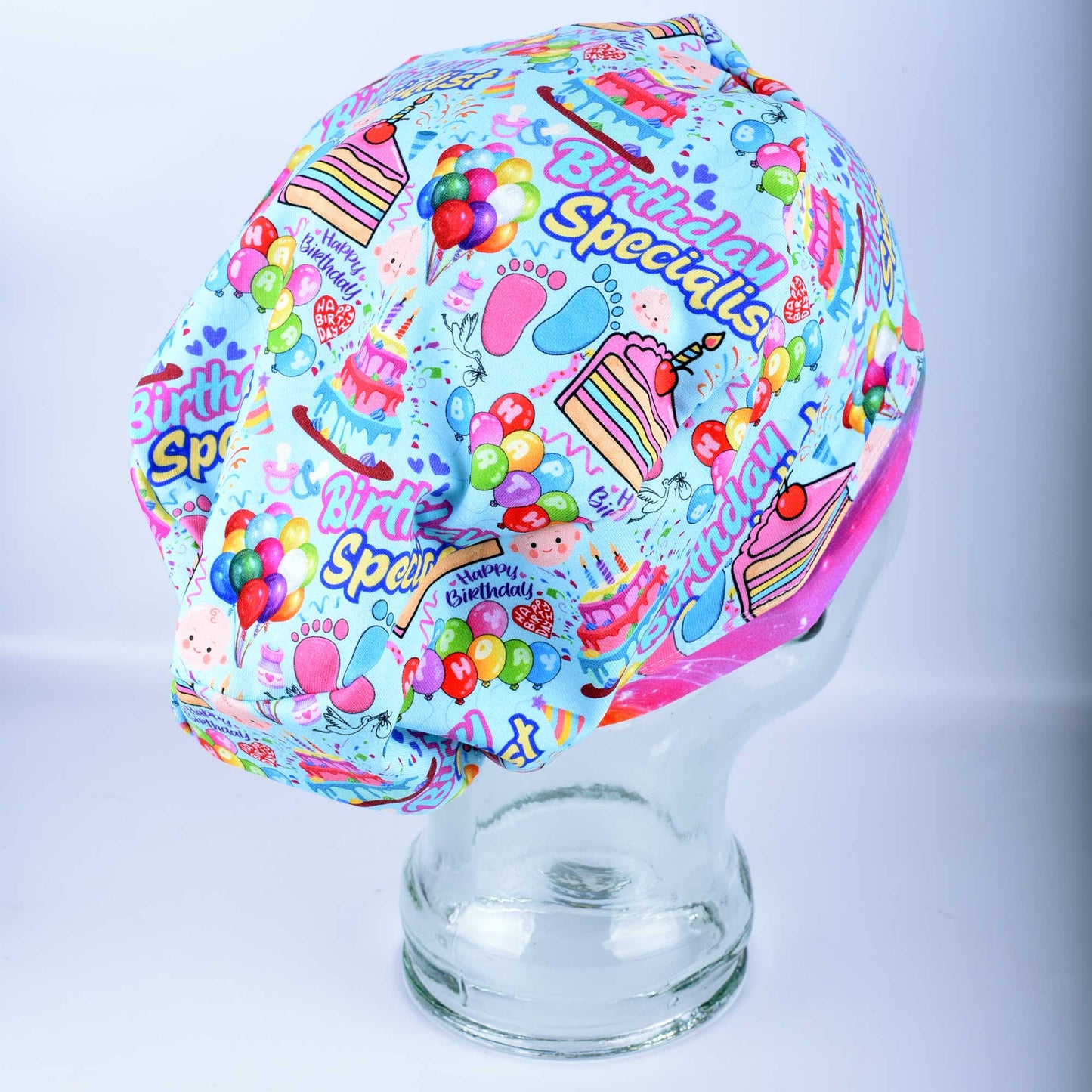 Side profile of a colorful Labor and Delivery scrub cap showing the full-coverage Euro-style design and vibrant celebratory pattern.