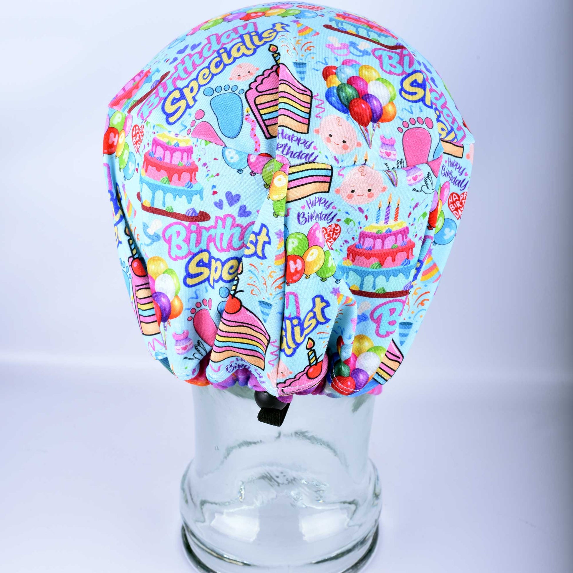 Back view of the Birthday Specialist scrub cap highlighting the adjustable cord lock toggle and encased elastic for a custom fit.