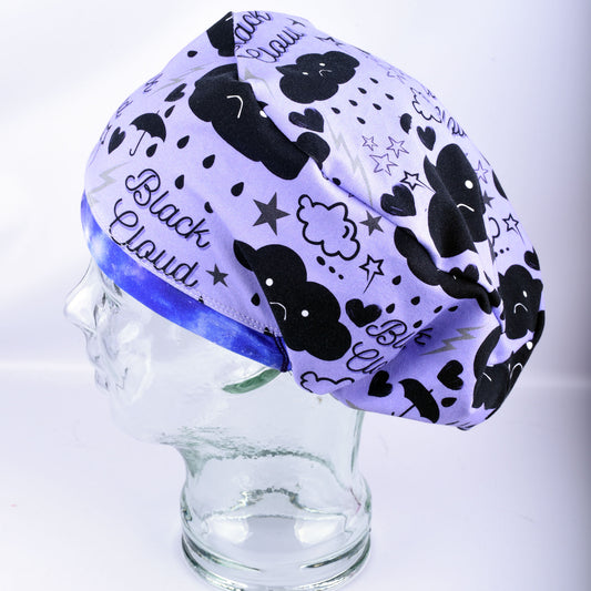 Close-up of a handmade stretchy knit scrub hat showing a pattern of dark clouds, lightning bolts, and rain.