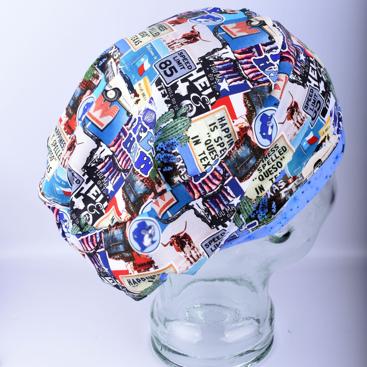 A multicolor scrub cap with a collage print of vintage Texas license plates, flags, and medical-themed graphics, displayed on a clear glass mannequin head against a light gray background.