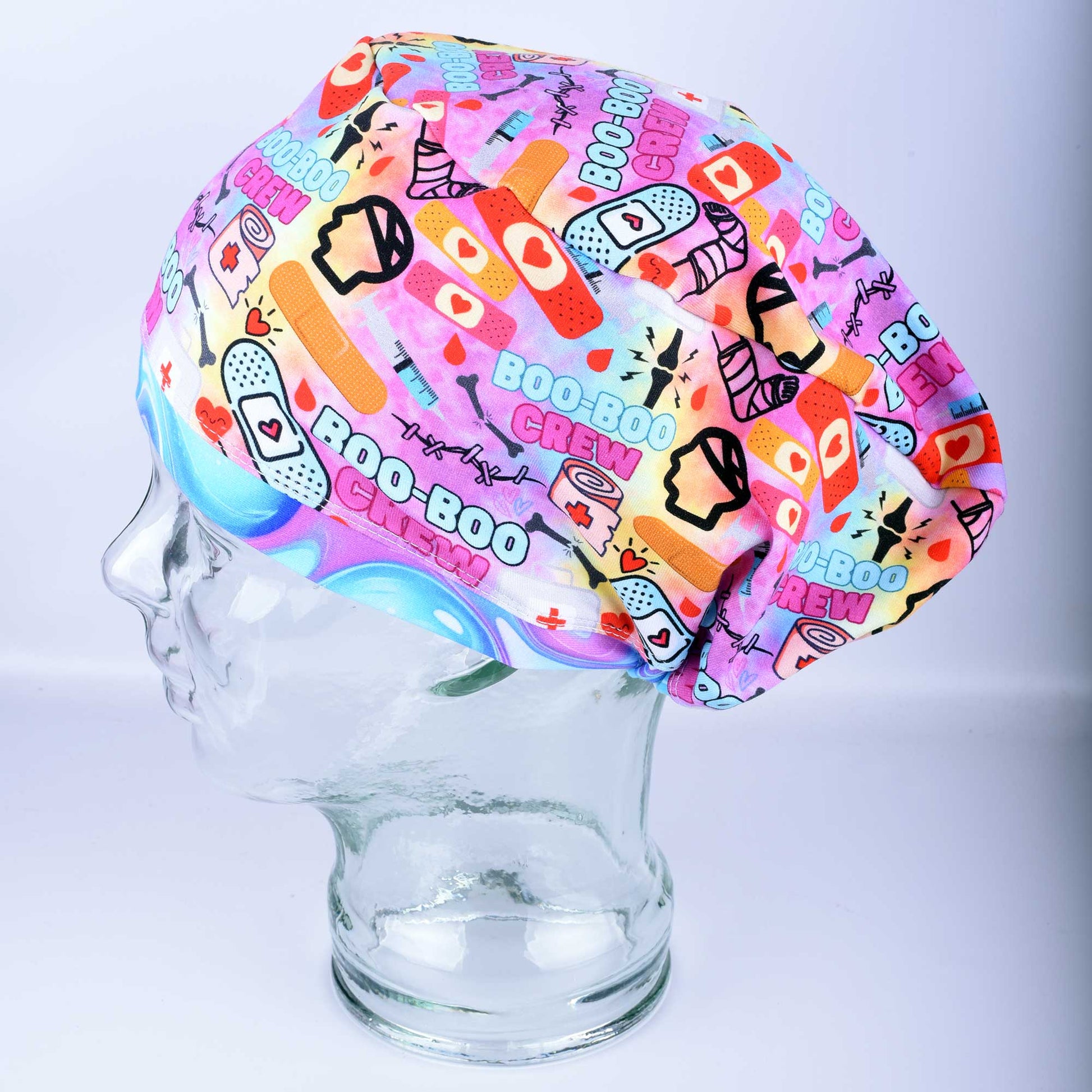 Close-up of Boo Boo Crew scrub cap featuring a playful medical-themed print on soft, stretchy fabric.