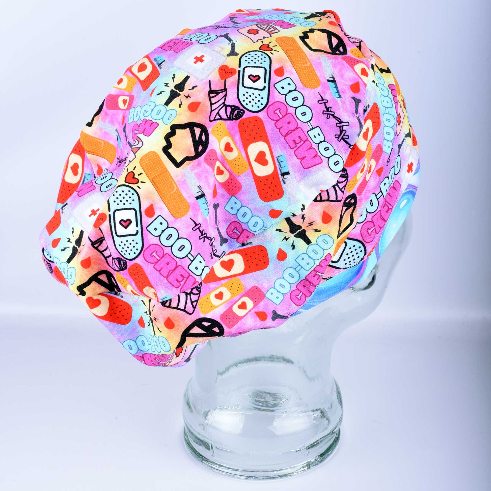 Close-up of Boo Boo Crew scrub cap featuring a playful medical-themed print on soft, stretchy fabric.