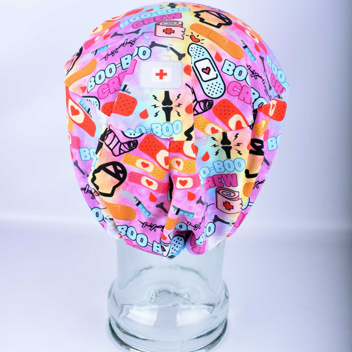 Close-up of Boo Boo Crew scrub cap featuring a playful medical-themed print on soft, stretchy fabric.