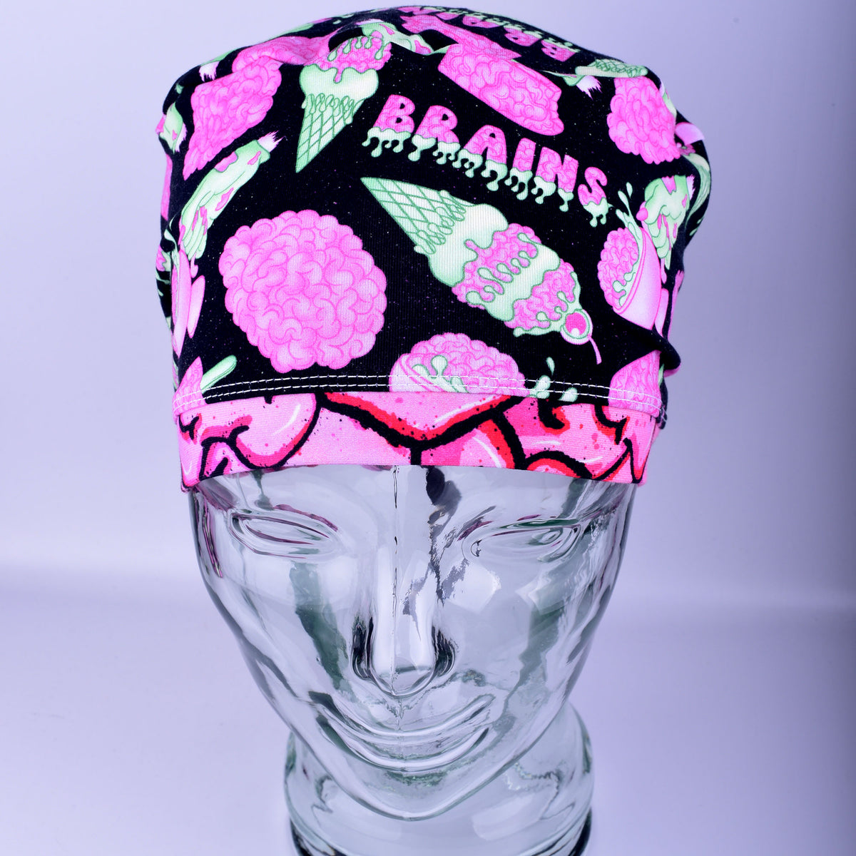 Front view of a white, black, and pink brain-patterned scrub cap on a display mannequin.