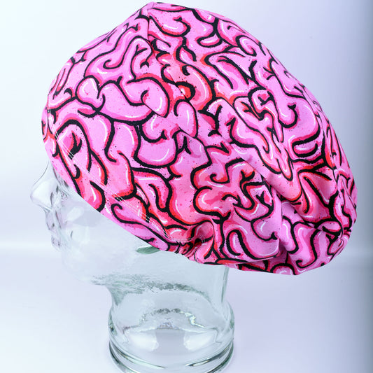Pink brain scrub cap on a glass mannequin head against a white background
