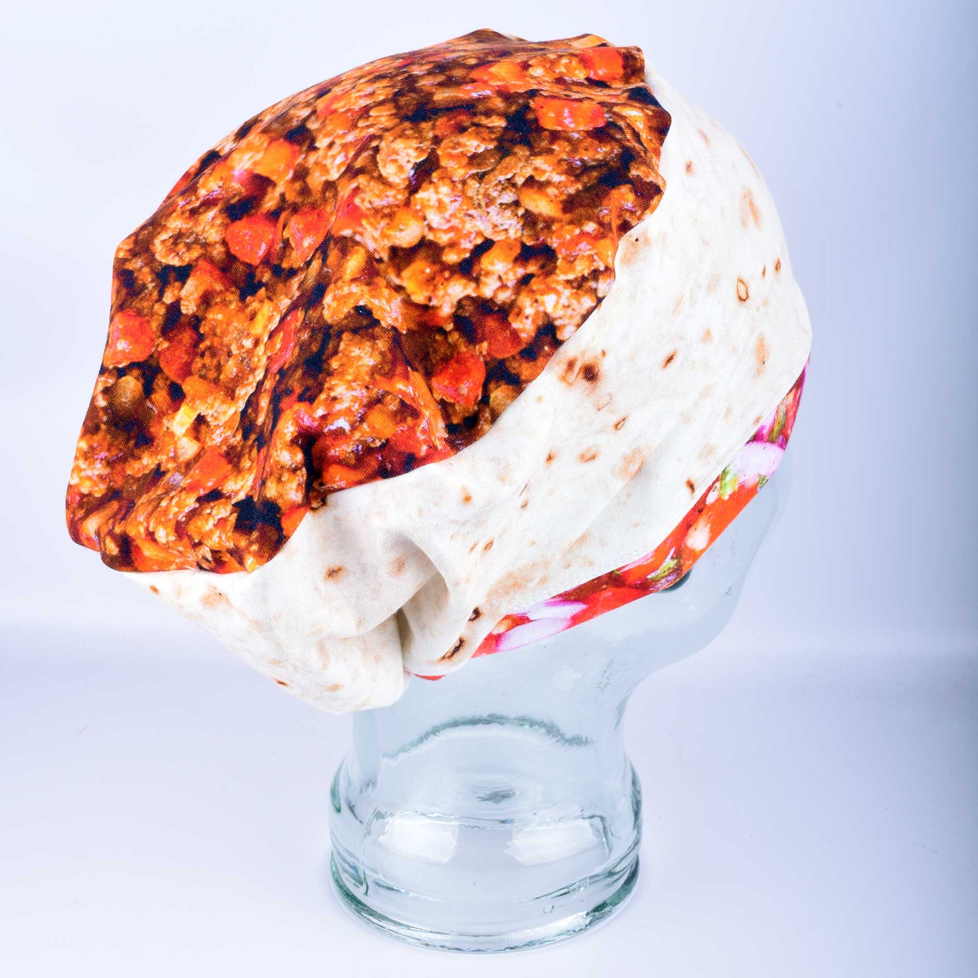 Full coverage scrub cap featuring a vibrant burrito and taco pattern on a mannequin head, showing the secure fit and adjustable cord lock toggle at the back.