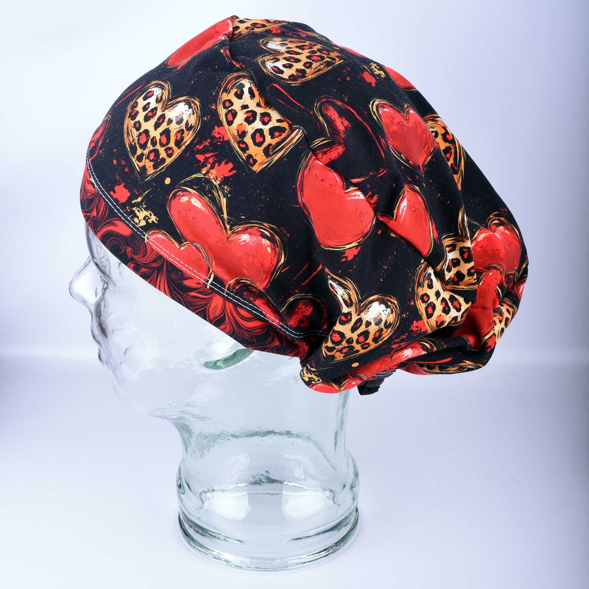 Classy Hearts Scrub Cap featuring a red and black heart pattern with cheetah print accents.