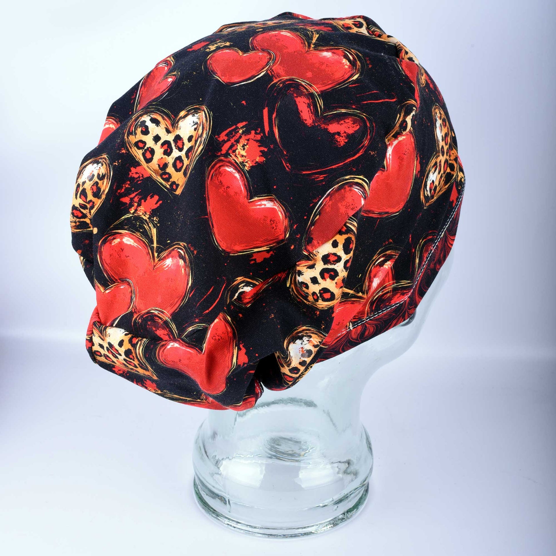 Classy Hearts Scrub Cap featuring a red and black heart pattern with cheetah print accents.