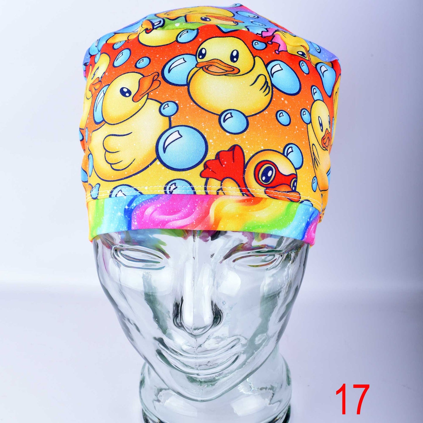 Detailed close-up of the premium, stretchy cotton-elastane fabric of a medical scrub hat, highlighting the crisp, colorful ducks and bubbles print and clean stitching.