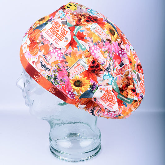 Handmade full-coverage Euro-style scrub cap featuring a festive pumpkin and fall leaves pattern in orange, red, and blue tones on a mannequin head.