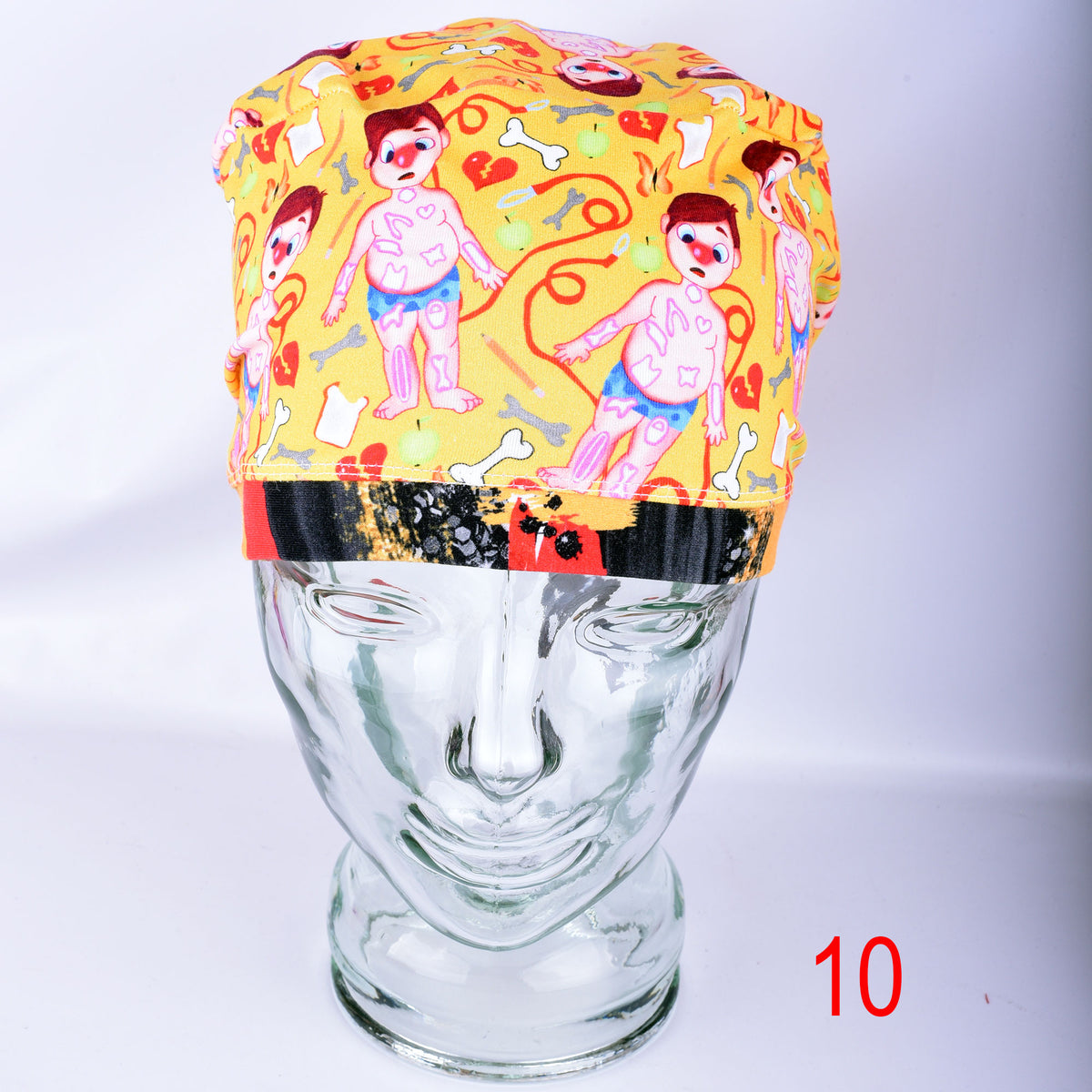 Colorful yellow scrub cap featuring cartoon medical patients and anatomical symbols on a glass mannequin head.