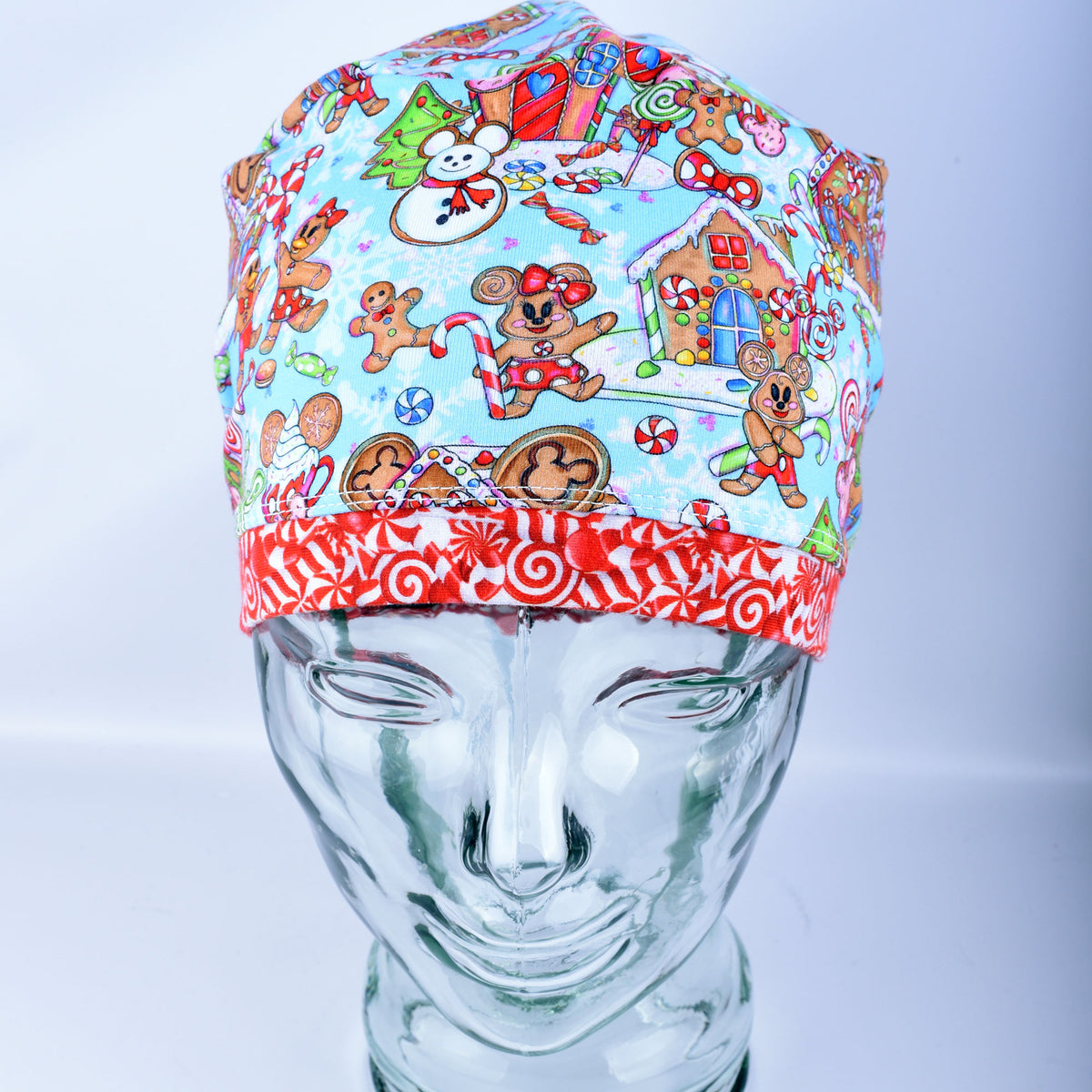 Close-up of a handcrafted cotton blend scrub cap showcasing a playful holiday print with festive winter treats and cheerful characters.