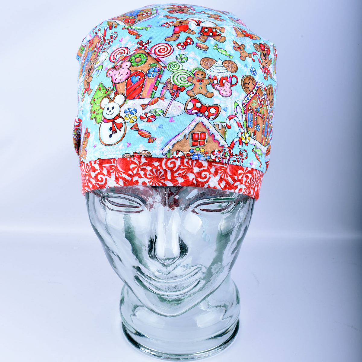 Close-up of a handcrafted cotton blend scrub cap showcasing a playful holiday print with festive winter treats and cheerful characters.