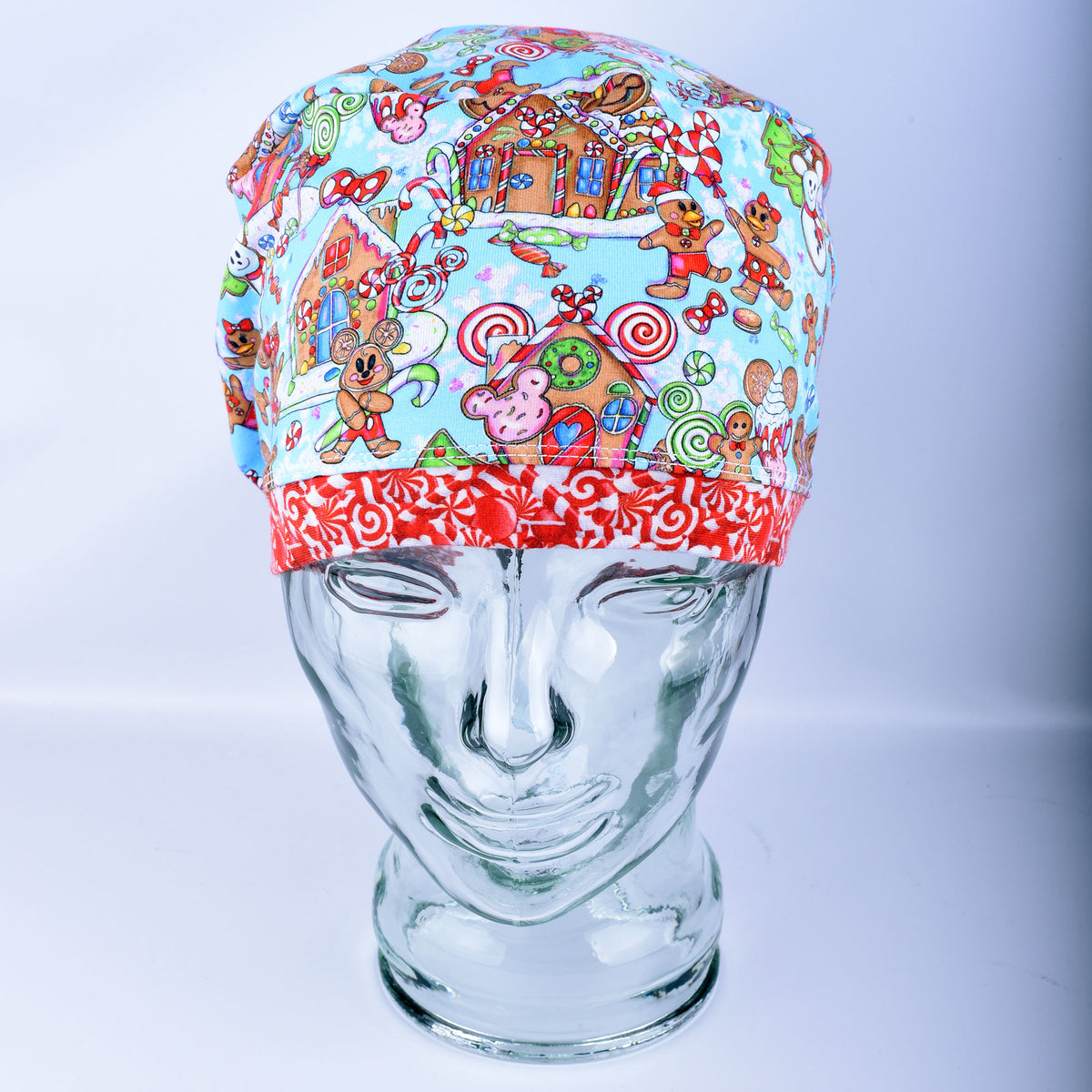 Close-up of a handcrafted cotton blend scrub cap showcasing a playful holiday print with festive winter treats and cheerful characters.