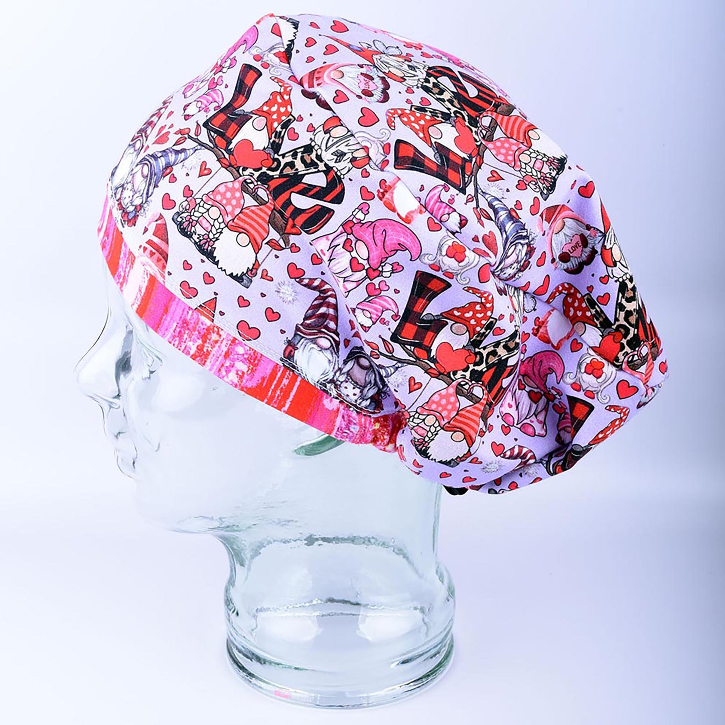 Side profile view of an adjustable knit scrub cap in a romantic gnome pattern, demonstrating full hair coverage and comfortable positioning over the ears.