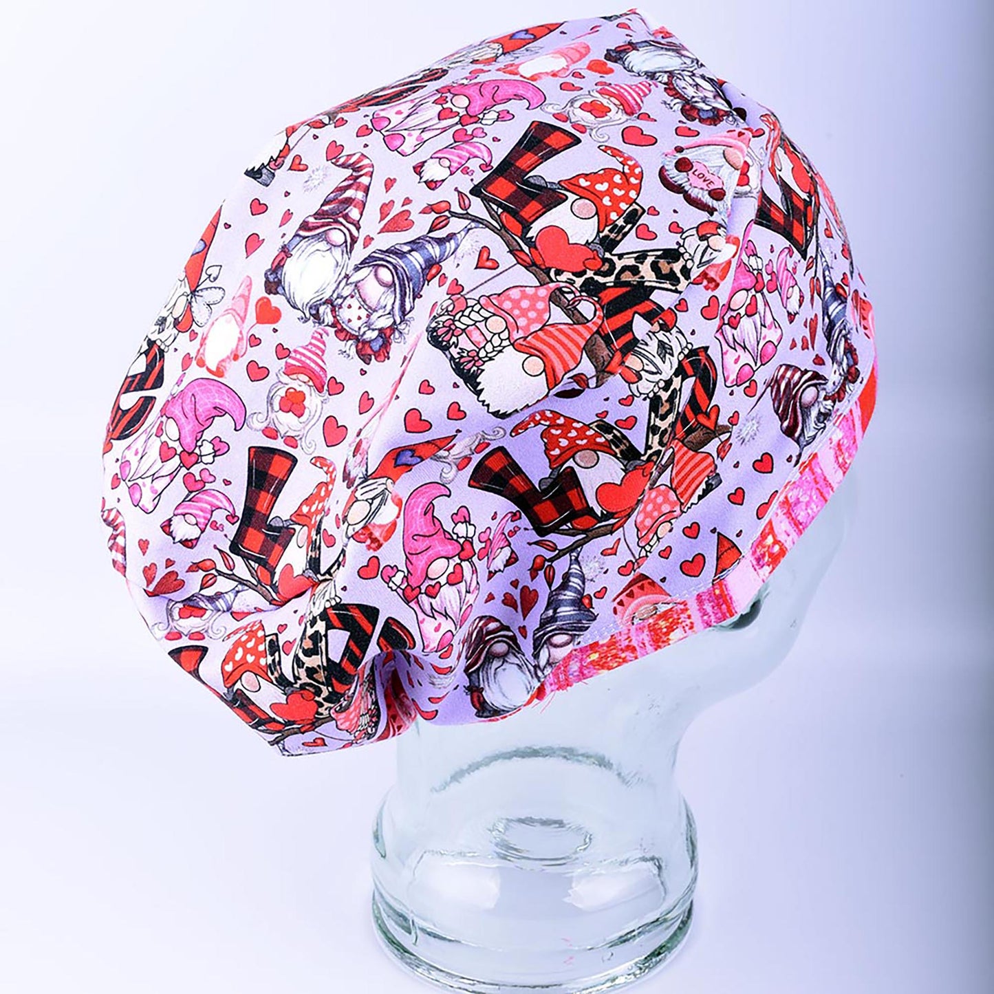 Side profile view of an adjustable knit scrub cap in a romantic gnome pattern, demonstrating full hair coverage and comfortable positioning over the ears.
