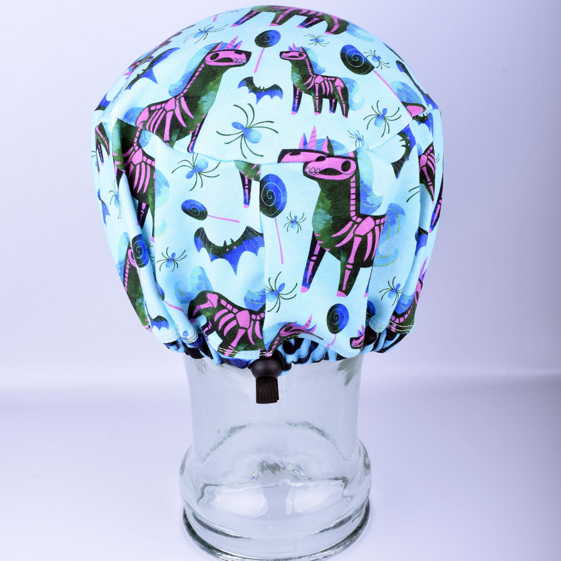 Back view of unicorn skeleton scrub cap showing encased elastic band and adjustable toggle closure.