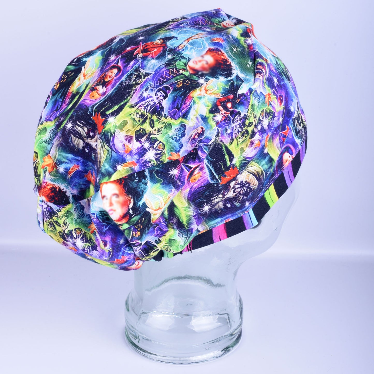 Side profile of a multi-colored cartoon witch pattern full coverage scrub cap showing the deep pouch fit.