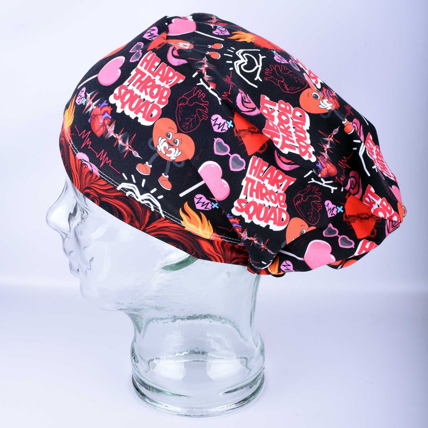 Heart Throb Squad Scrub Cap in a full-coverage style featuring a vibrant red and black cardiology-themed heart pattern.