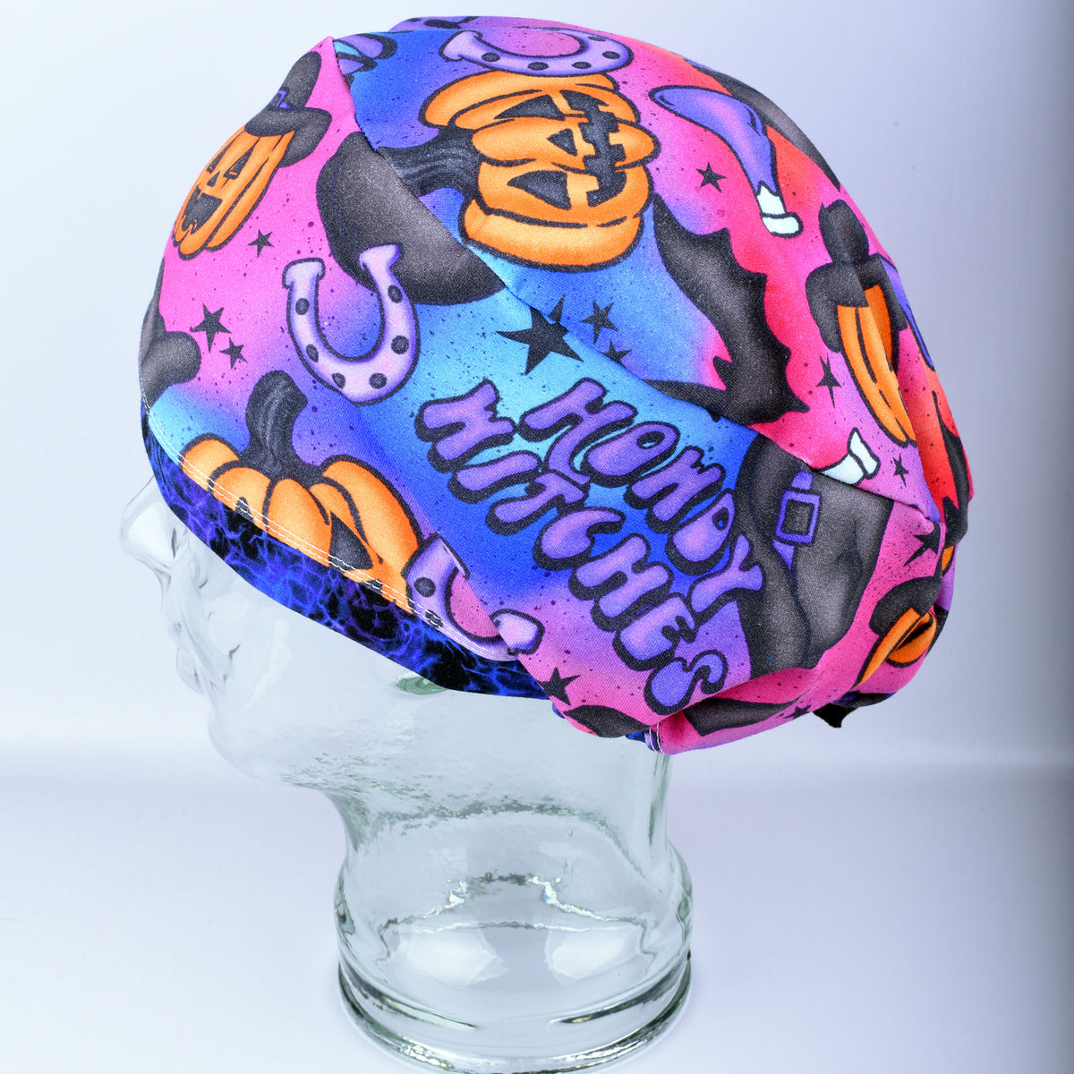Side profile view of the Howdy Witches medical scrub cap, highlighting the roomy full-coverage fit and continuous spooky cowboy-witch pattern layout.