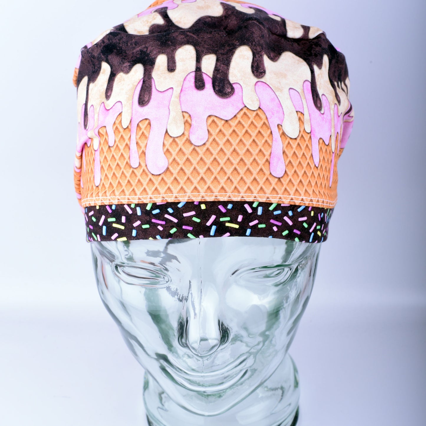 Front view of a stretchy cotton surgical hat featuring a colorful melted ice cream pattern for healthcare professionals.