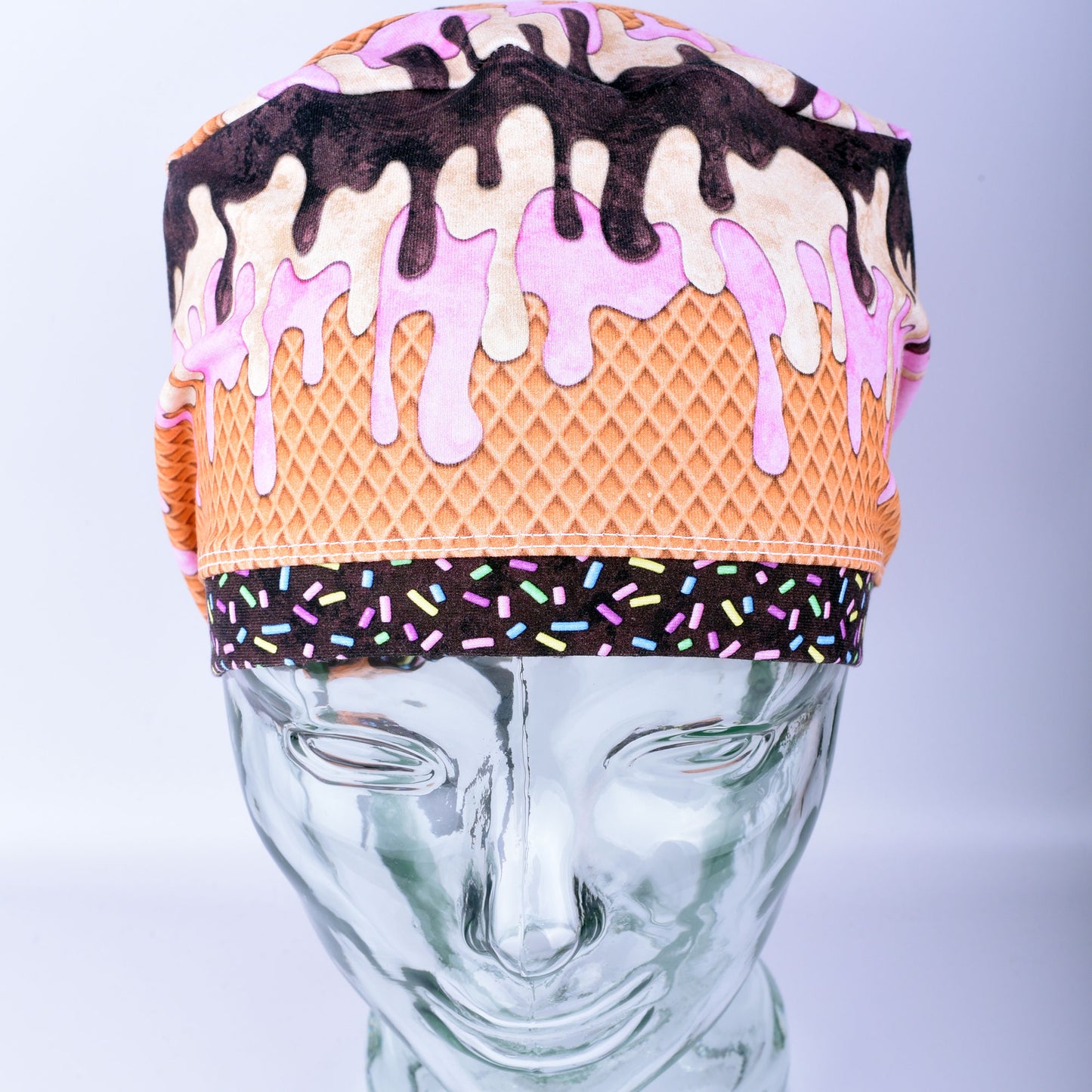 Front view of a stretchy cotton surgical hat featuring a colorful melted ice cream pattern for healthcare professionals.