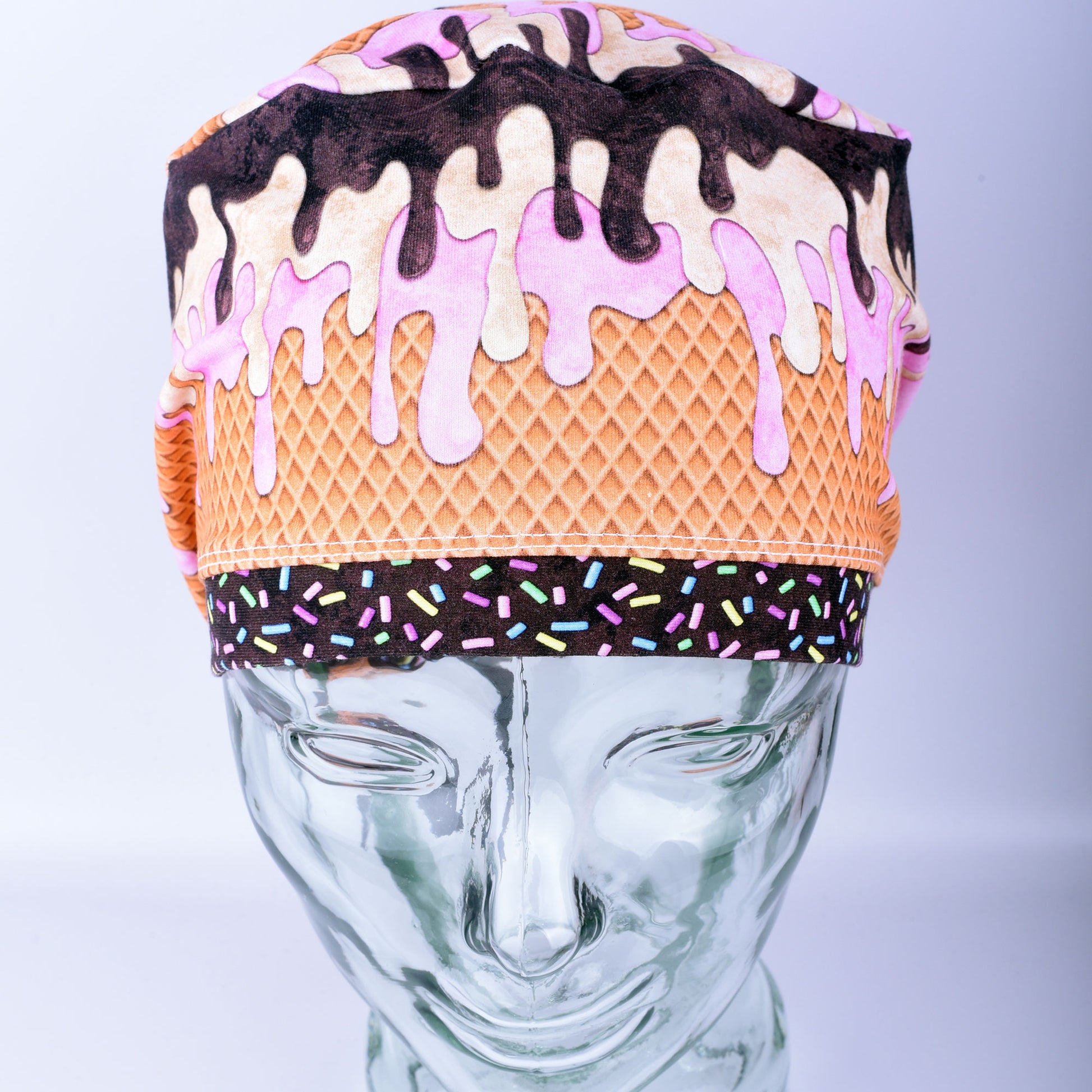 Front view of a stretchy cotton surgical hat featuring a colorful melted ice cream pattern for healthcare professionals.