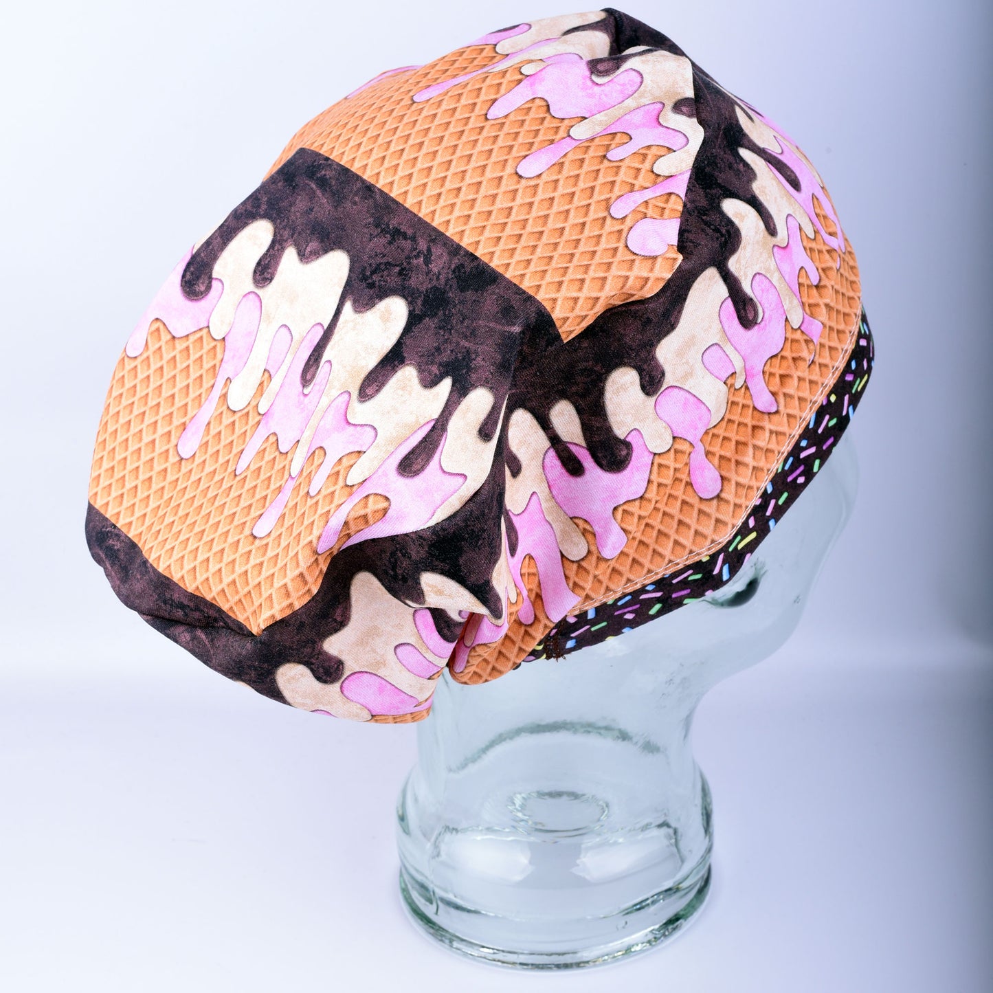 Side view of an adjustable scrub cap with a heavy-duty cord lock toggle and elastic band for a custom fit.