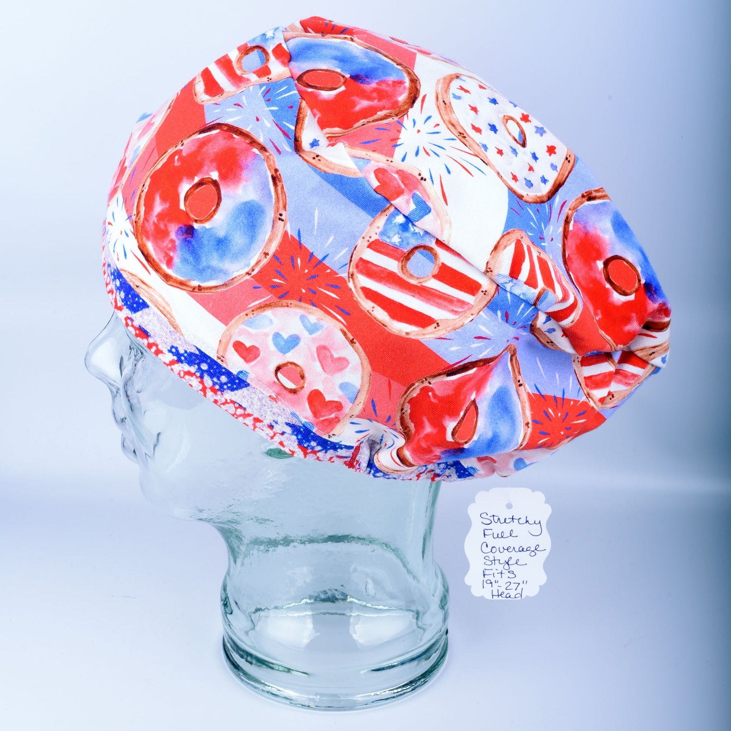 Handmade full coverage scrub cap with a patriotic donut print featuring red, white, and blue stars and sprinkles on a white background.