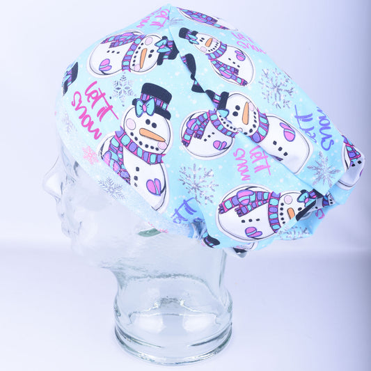 A light blue Euro-style scrub cap featuring a festive, colorful snowman and snowflake pattern, displayed on a clear mannequin head to showcase its full-coverage fit.