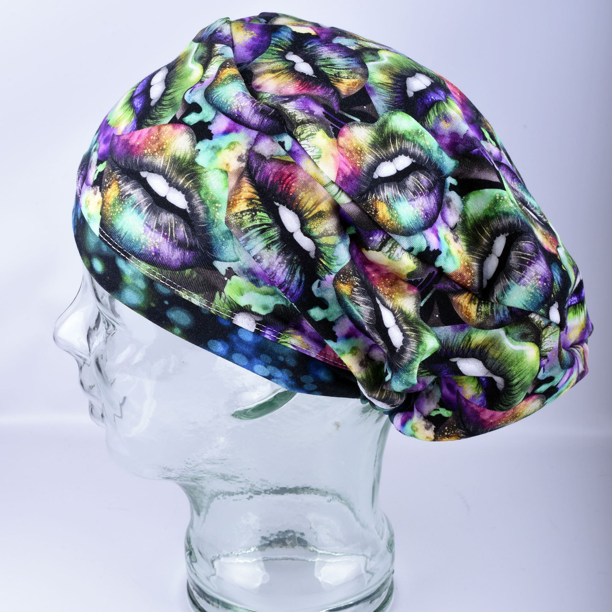 Side profile of an adjustable knit scrub cap in a multicolor holiday lip pattern, demonstrating the smooth fit around the ears and full hair coverage.