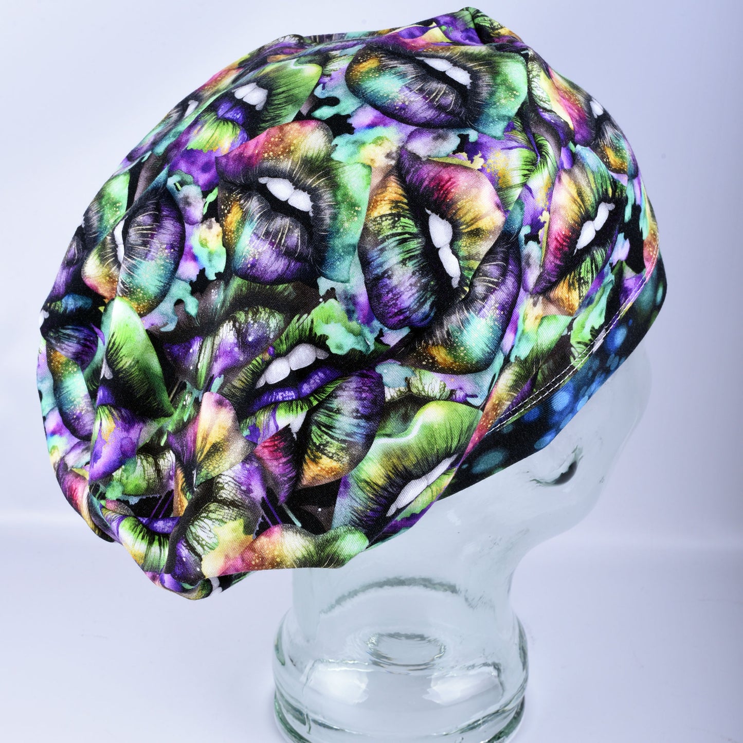 Side profile of an adjustable knit scrub cap in a multicolor holiday lip pattern, demonstrating the smooth fit around the ears and full hair coverage.