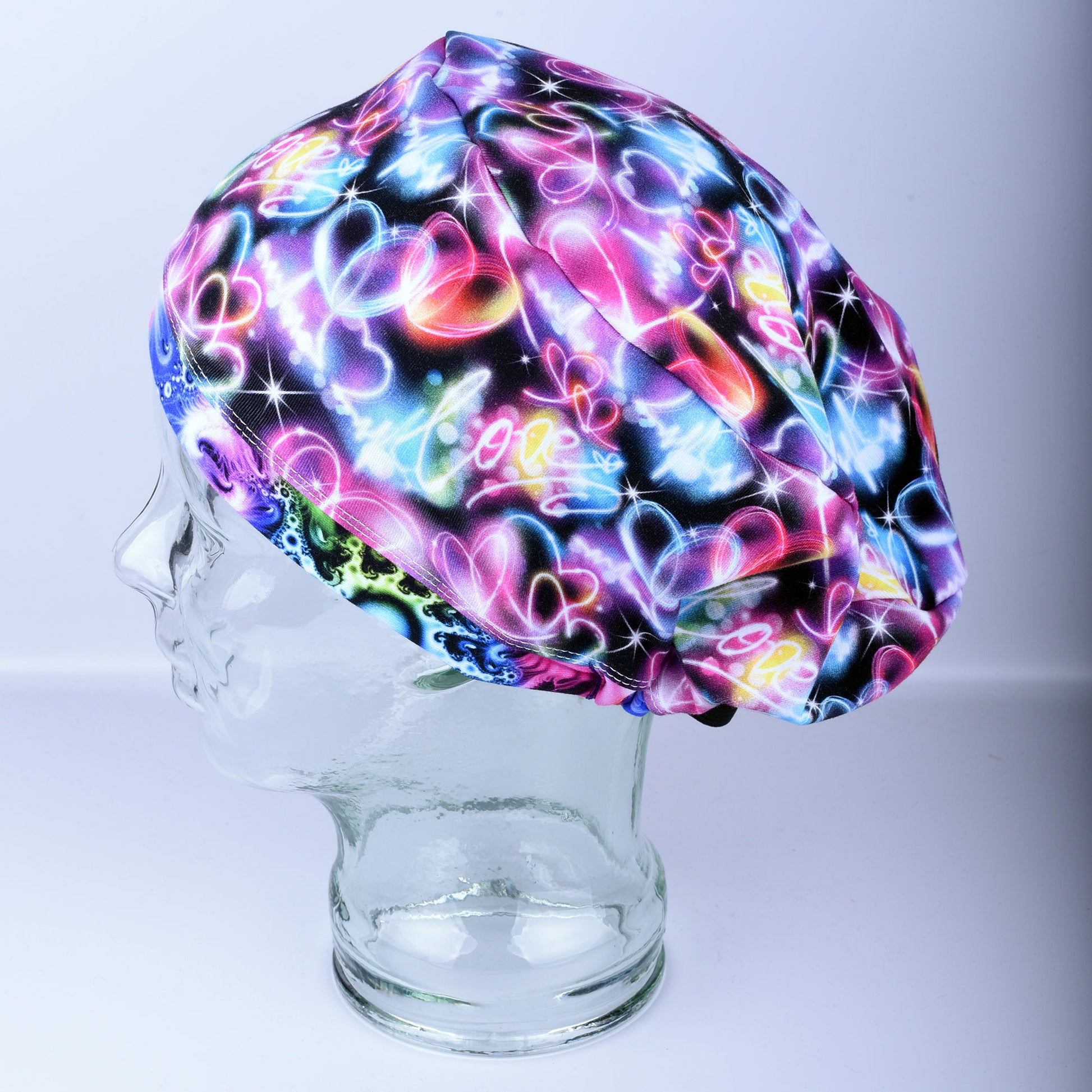 Neon Hearts Scrub Cap for medical professionals featuring a vibrant multicolor heart print on a black background
