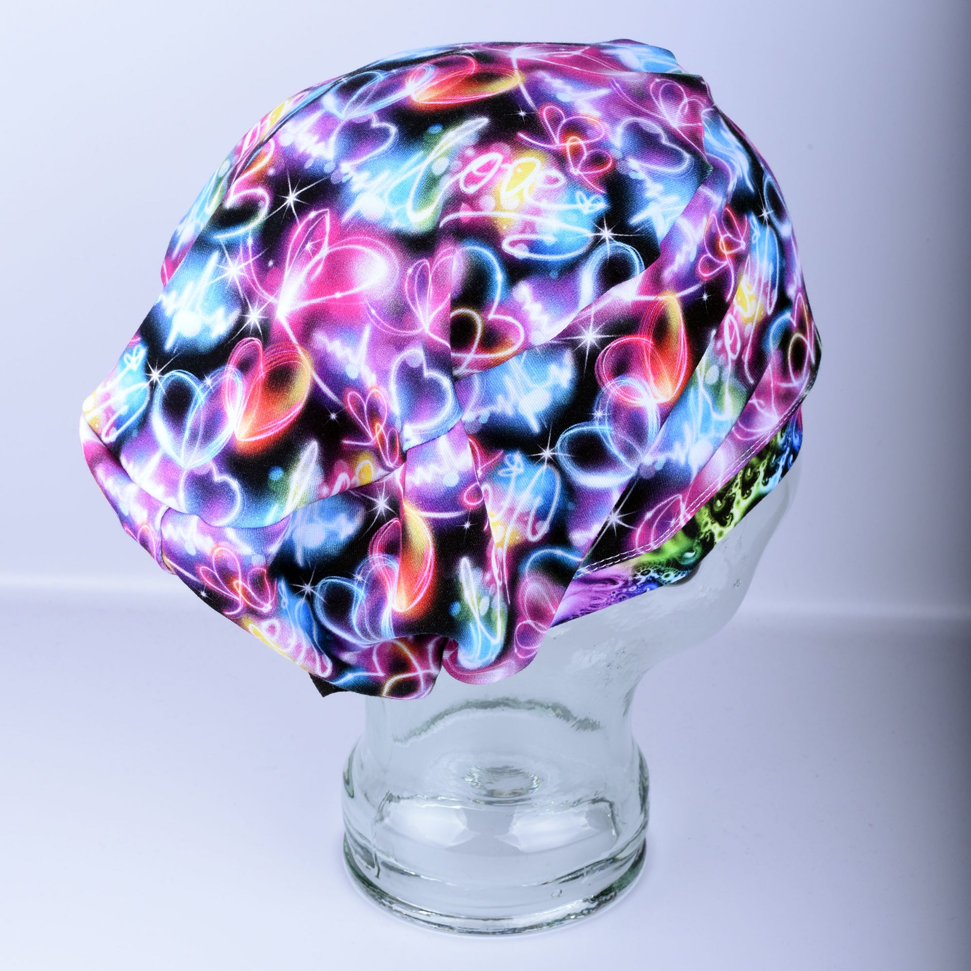Neon Hearts Scrub Cap for medical professionals featuring a vibrant multicolor heart print on a black background
