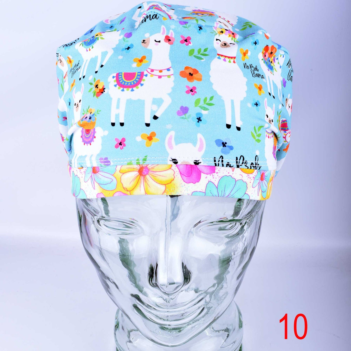 No Prob Llama full coverage scrub cap featuring a whimsical blue and white llama and floral pattern on a light background.