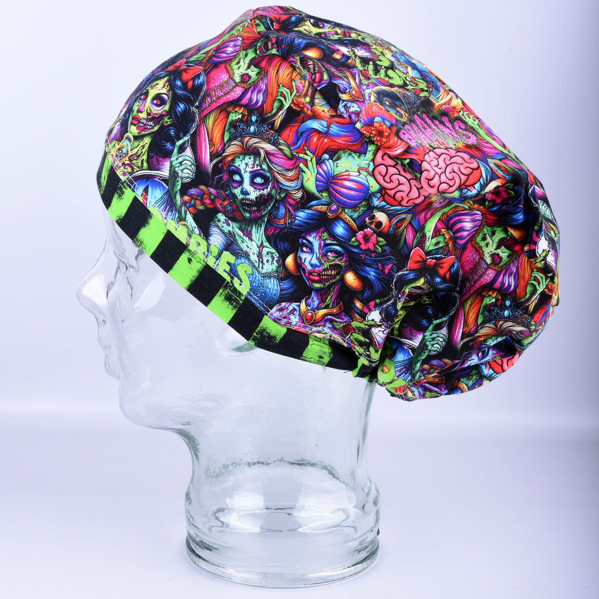 A colorful, highly detailed Princess Zombies print scrub cap displayed on a clear glass mannequin head against a light gray background.