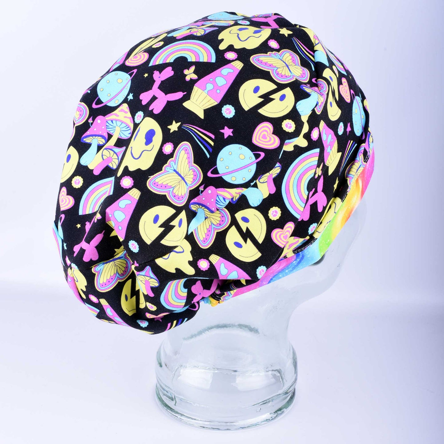 Side view of the Retro Days Full Coverage Scrub Cap on a clear mannequin head, showcasing the nostalgic 70s-inspired multicolor print and adjustable design.