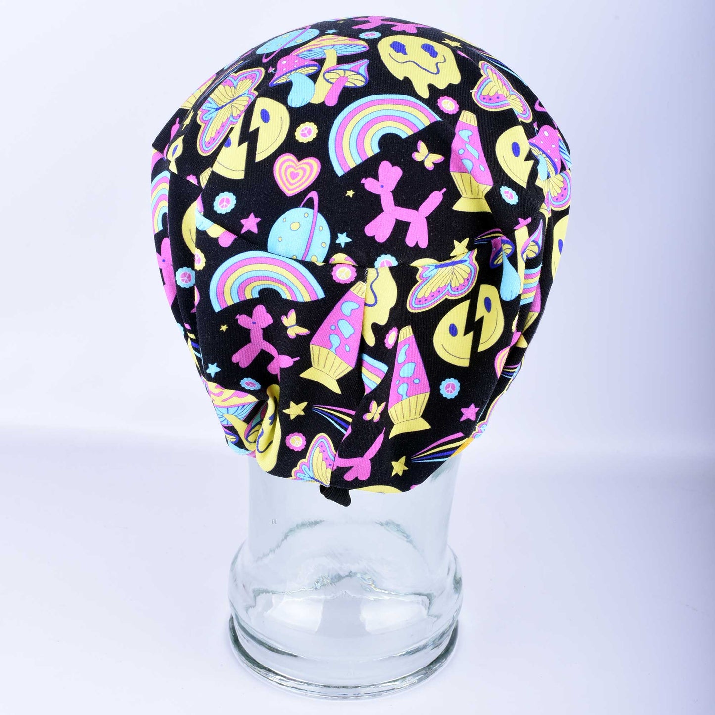 Back view of the Retro Days Full Coverage Scrub Cap on a clear mannequin head, showcasing the nostalgic 70s-inspired multicolor print and adjustable design.