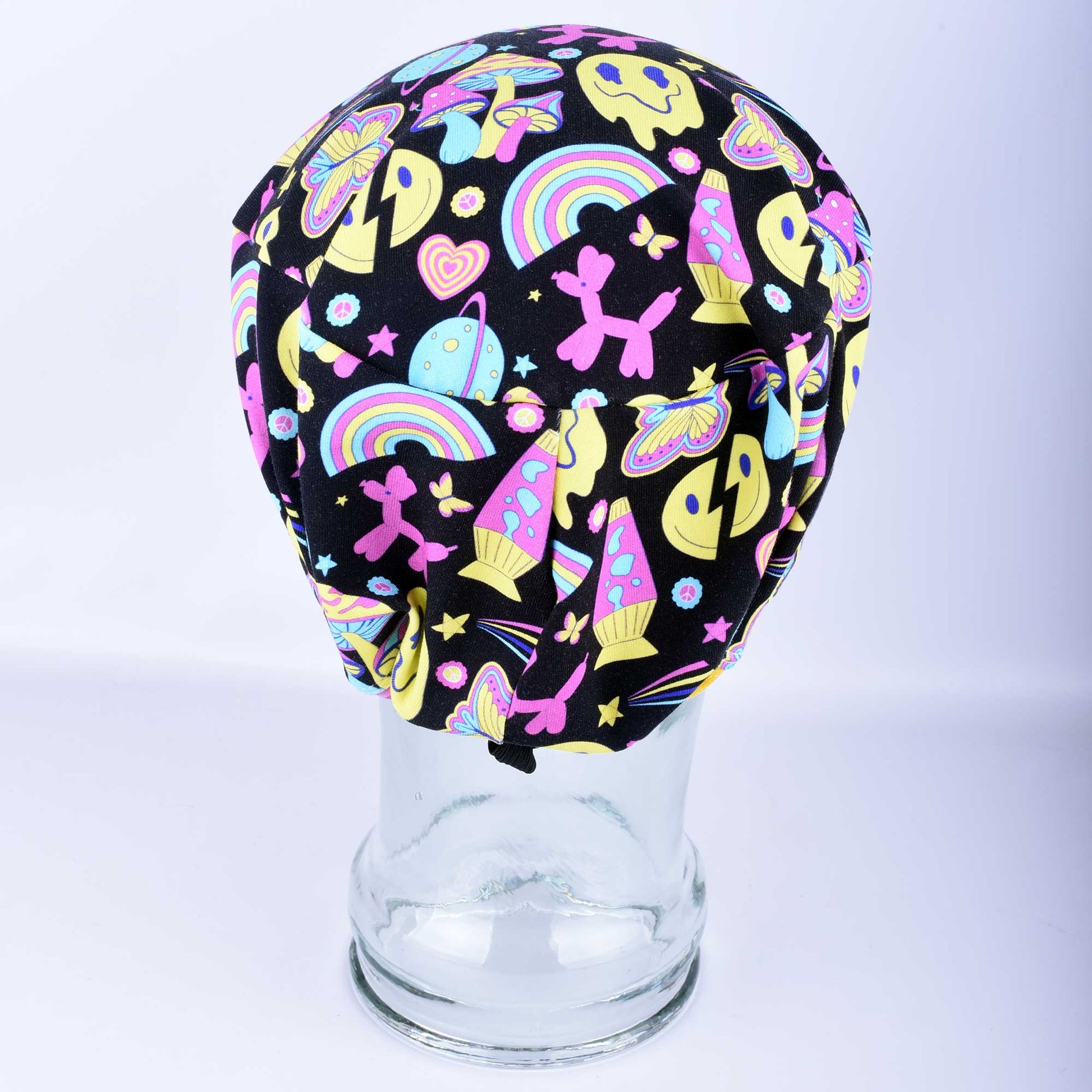 Back view of the Retro Days Full Coverage Scrub Cap on a clear mannequin head, showcasing the nostalgic 70s-inspired multicolor print and adjustable design.